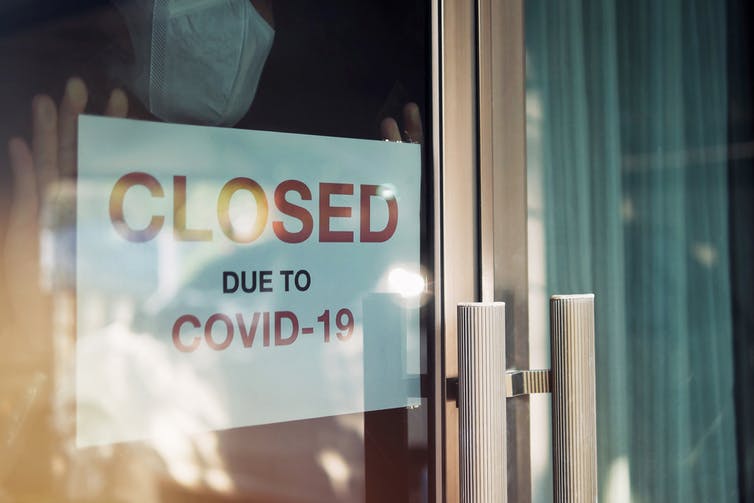 Poster in a window saying "Closed due to COVID-19"