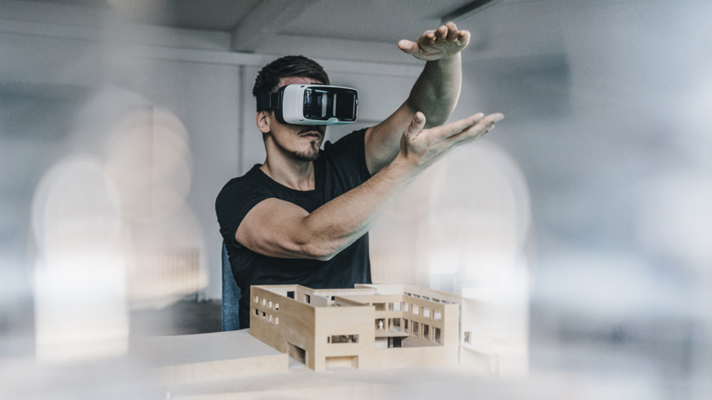 Man wearing a VR headset with a physical architectural model.